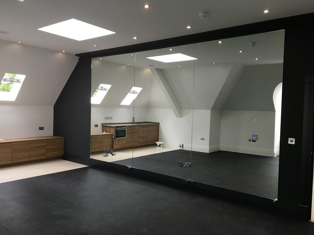 Frameless glass wall dividing loft conversion in Upper Edmonton